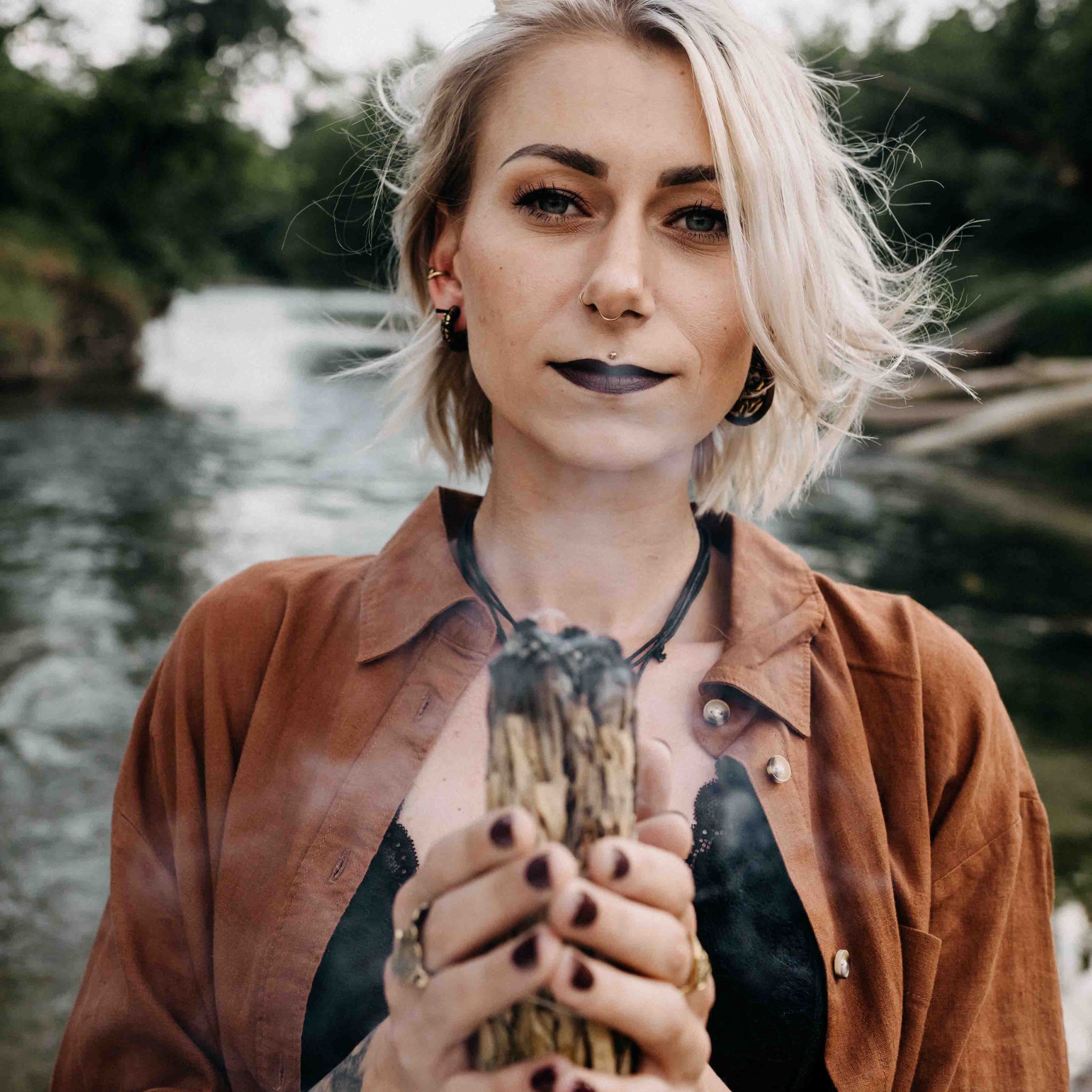 Frau mit Schmuck und Holz in der Hand das raucht