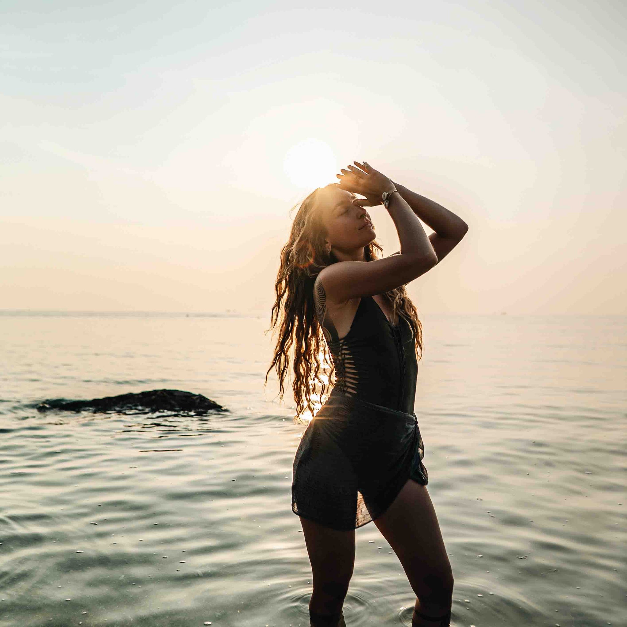 Frau mit dankendem Zeichen im Wasser stehend