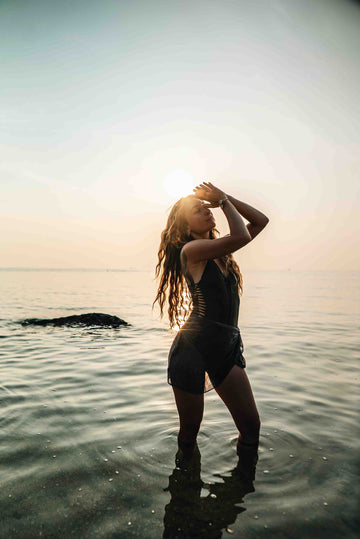 Frau mit dankendem Zeichen im Wasser stehend